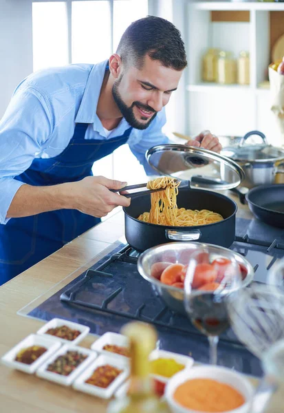 家のキッチンでおいしいと健康食品を準備する男 — ストック写真