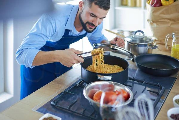 家のキッチンでおいしいと健康食品を準備する男 — ストック写真