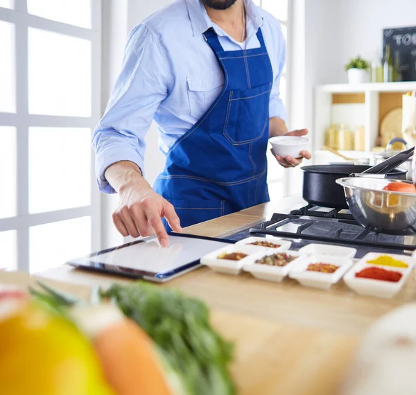 家のキッチンでおいしいと健康食品を準備する男 — ストック写真