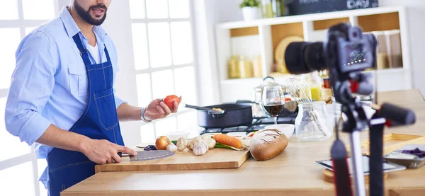 Mann hält Papiertüte voller Lebensmittel auf dem Küchenhintergrund. Shopping und gesundes Ernährungskonzept — Stockfoto