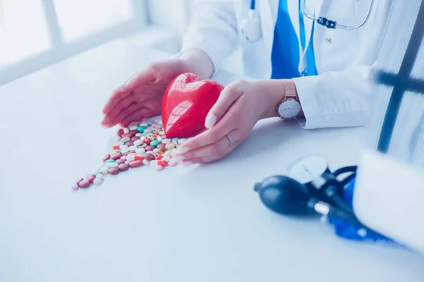 Cardiologue avec coeur rouge et stéthoscope à table — Photo