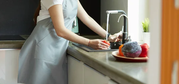 Donna che lava pomodori nel lavandino della cucina da vicino — Foto Stock
