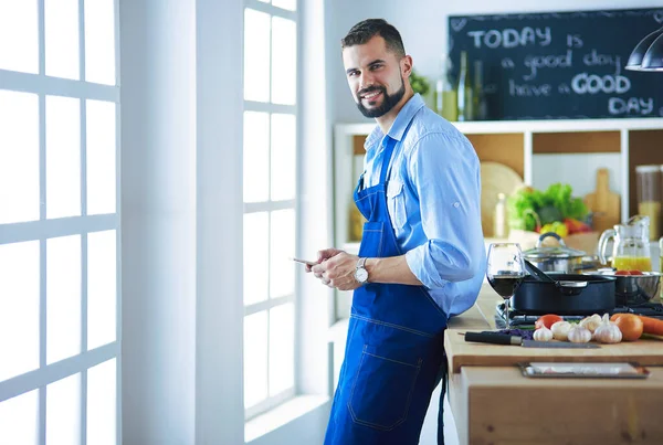 Mann hält Papiertüte voller Lebensmittel auf dem Küchenhintergrund. Shopping und gesundes Ernährungskonzept — Stockfoto