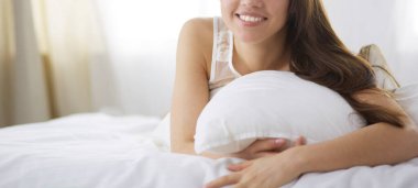 Güzel bir kadın yatağında uzanıyor.