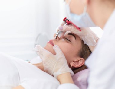 Kırmızı dudaklı genç bir kız kalıcı makyaj, mikro pigmentasyon