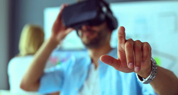 Jovem programador de software masculino testando um novo aplicativo com óculos de realidade virtual 3d no escritório . — Fotografia de Stock