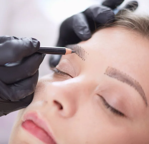 Cosmetologist applying permanent make up on eyebrows — Stock Photo, Image