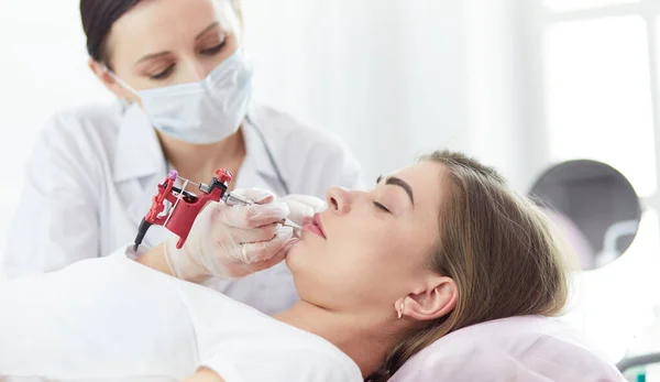 A young girl having red lips permanent makeup, micropigmentation — Stock Photo, Image