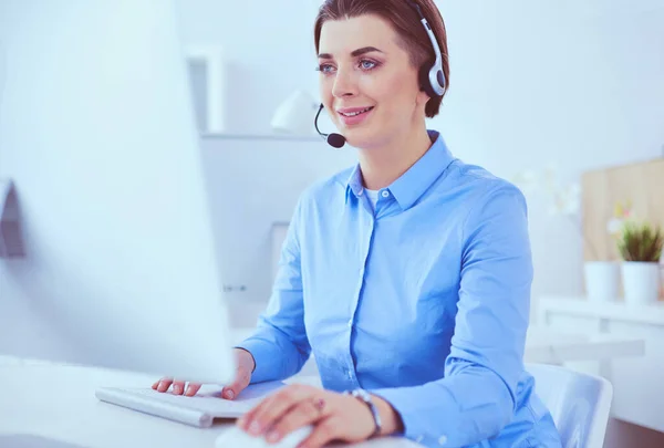 Serious pretty young woman working as support phone operator with headset in office — Stock Photo, Image