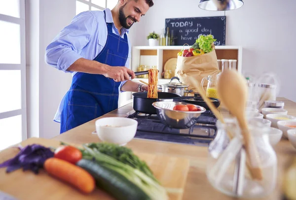 家のキッチンでおいしいと健康食品を準備する男 — ストック写真