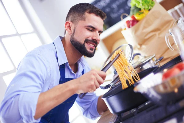 Muž připravuje lahodné a zdravé jídlo v domácí kuchyni — Stock fotografie