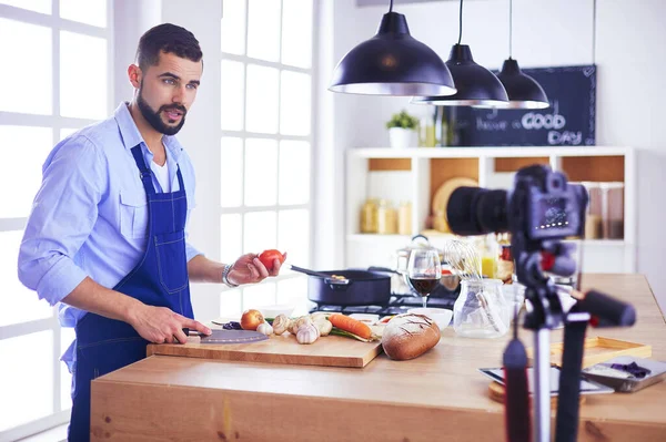 Mann hält Papiertüte voller Lebensmittel auf dem Küchenhintergrund. Shopping und gesundes Ernährungskonzept — Stockfoto