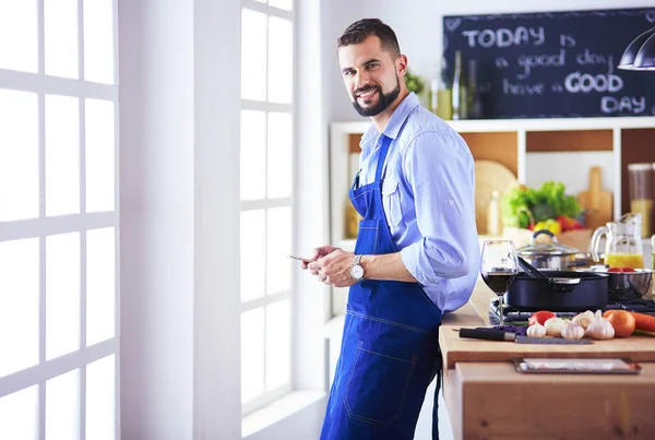 Mann hält Papiertüte voller Lebensmittel auf dem Küchenhintergrund. Shopping und gesundes Ernährungskonzept — Stockfoto