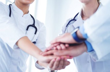 Birçok mutlu doktor motivasyon için el ele tutuşur.