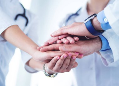 Birçok mutlu doktor motivasyon için el ele tutuşur.