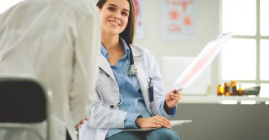 Doktor ve hasta masada otururken bir şey tartışıyorlar. İlaç ve sağlık hizmetleri kavramı