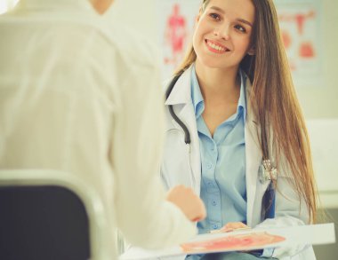 Doktor ve hasta masada otururken bir şey tartışıyorlar. İlaç ve sağlık hizmetleri kavramı