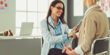 Doktor ve hasta masada otururken bir şey tartışıyorlar. İlaç ve sağlık hizmetleri kavramı