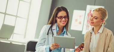 Doktor ve hasta masada otururken bir şey tartışıyorlar. İlaç ve sağlık hizmetleri kavramı