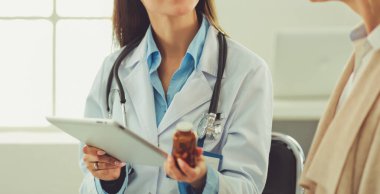 Doktor ve hasta masada otururken bir şey tartışıyorlar. İlaç ve sağlık hizmetleri kavramı