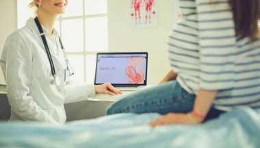 Hastanede doktorla gülümseyen güzel bir hamile kadın.