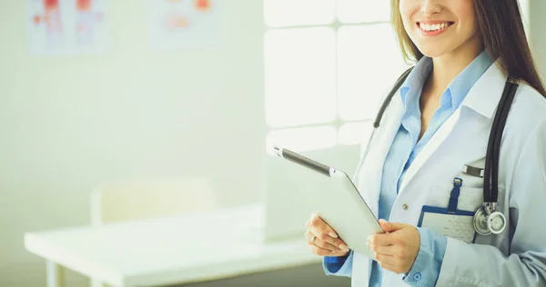 Female doctor using tablet computer in hospital lobby