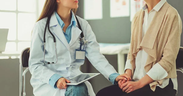 Médico e paciente discutindo algo enquanto se senta na mesa. Conceito de medicina e cuidados de saúde — Fotografia de Stock