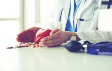 Masada kırmızı kalbi ve steteskopu olan kardiyolog.