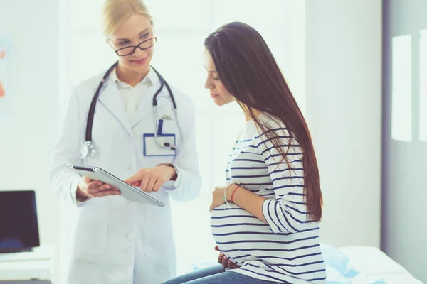Красивая, улыбающаяся беременная женщина с доктором в больнице — стоковое фото