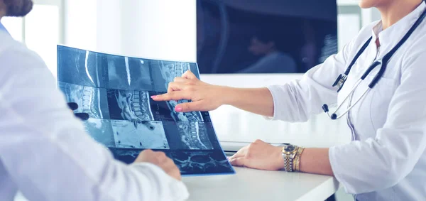 Dois médicos estudando imagem de raios-x, consultoria em escritório brilhante — Fotografia de Stock