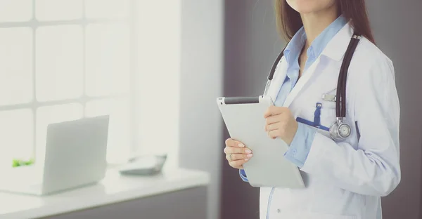 Female doctor using tablet computer in hospital lobby