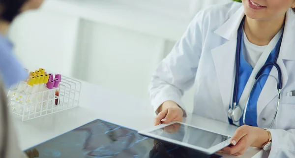 Female doctor using tablet computer in hospital lobby, smiling — Stock Photo, Image