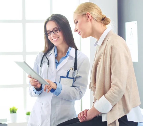 Doktorn och patienten diskuterar något när de sitter vid bordet. Medicin och hälsovård — Stockfoto