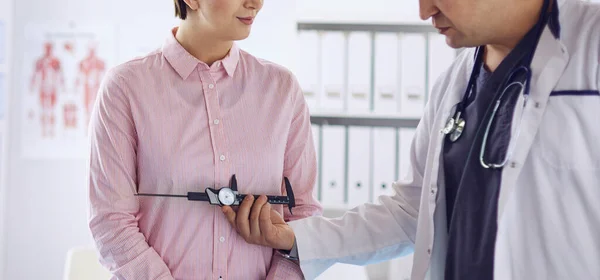 Doctor showing young patient her chest in his office at the hospital — Stock Photo, Image