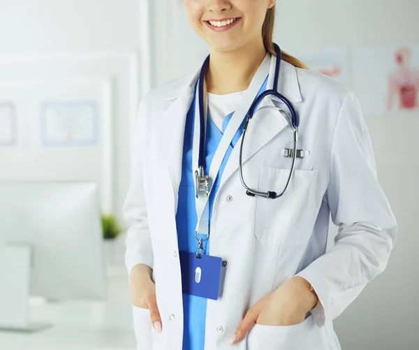 Portrait of young woman doctor with white coat standing in hospital Stock Photo