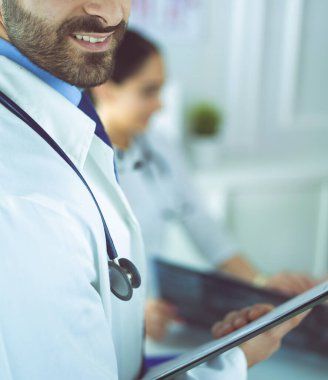 Dosyası olan erkek doktor, beyaz arka planda izole edilmiş.