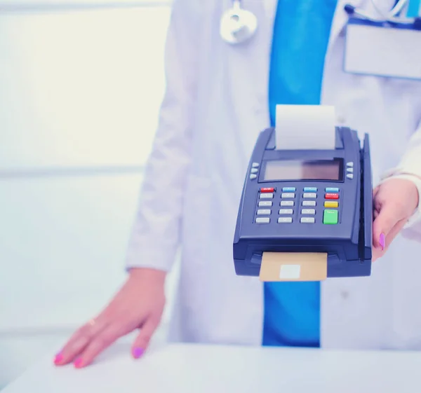 Le docteur tient le terminal de paiement entre les mains. Payer pour les soins de santé. Docteur. — Photo