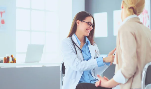 Dokter en patiënt bespreken iets terwijl ze aan tafel zitten. Begrip "geneeskunde en gezondheidszorg" — Stockfoto