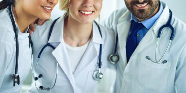 Başarılı tıbbi ekip. Kendine güvenen doktorlar bir arada durur ve gülümserler.