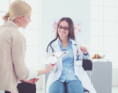 Doktor ve hasta masada otururken bir şey tartışıyorlar. İlaç ve sağlık hizmetleri kavramı