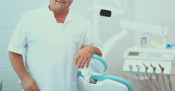 Portrait of a smiling dentist standing in dental clinic — Stock Photo, Image