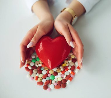 Masada kırmızı kalbi ve steteskopu olan kardiyolog.