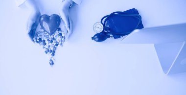 Masada kırmızı kalbi ve steteskopu olan kardiyolog.