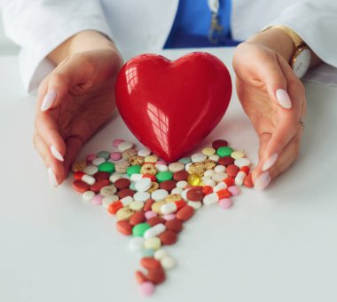 Masada kırmızı kalbi ve steteskopu olan kardiyolog.