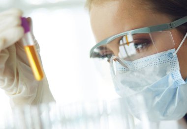 Modern laboratuvar veya hastanede plastik tıbbi tüplerle çalışan araştırmacı, doktor, bilim adamı veya laboratuvar asistanı