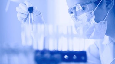 Laboratuvarda sıvı yeşil çözeltiye bakan bir tıbbi veya bilimsel araştırmacı ya da doktor