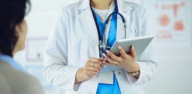 Doktor ve hasta masada otururken bir şey tartışıyorlar. İlaç ve sağlık hizmetleri kavramı