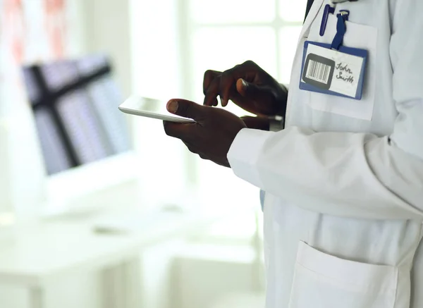 Homem negro médico trabalhador com tablet computador de pé no hospital — Fotografia de Stock