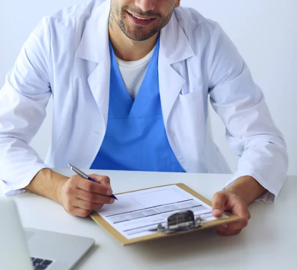 Retrato de un médico varón con portátil sentado en el escritorio en el consultorio médico. — Foto de Stock