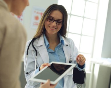 Doktor ve hasta masada otururken bir şey tartışıyorlar. İlaç ve sağlık hizmetleri kavramı